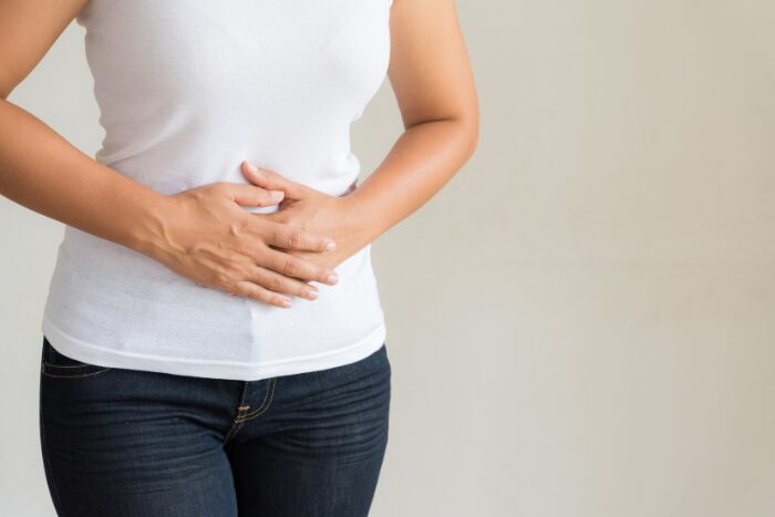 お腹に手を当てる女性
